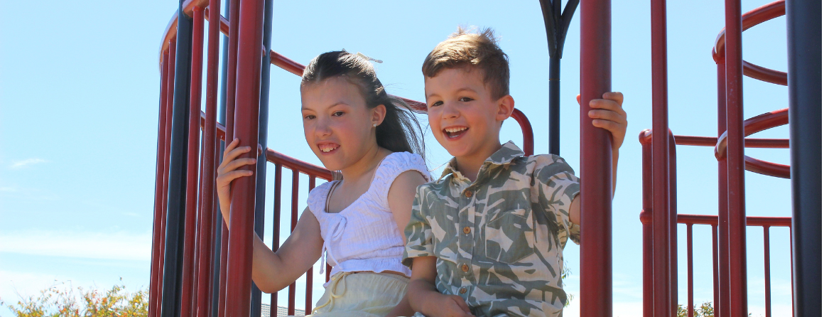 Amelia and Elijah smiling at a playground