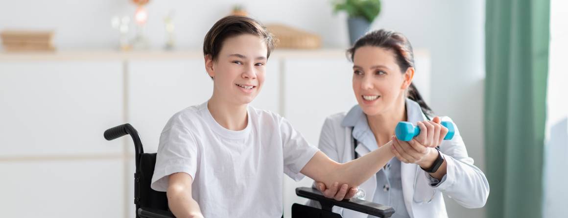 child in wheelchair with physio