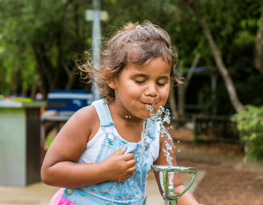 First Nations child drinking from a water fountain