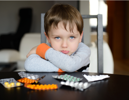 Child sitting down with antibiotics