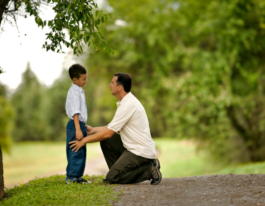Adult comforting child in a park