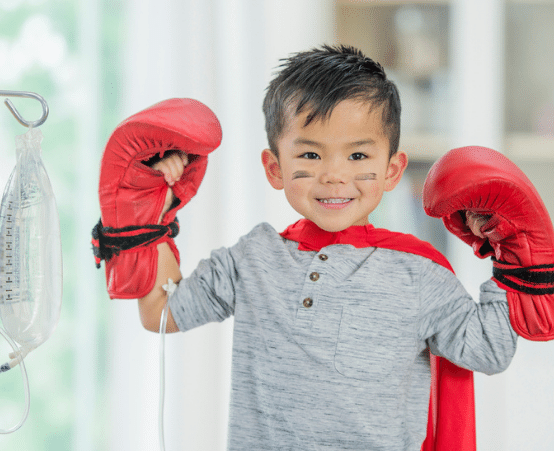Child wearing boxing gloves and smiling at the camera
