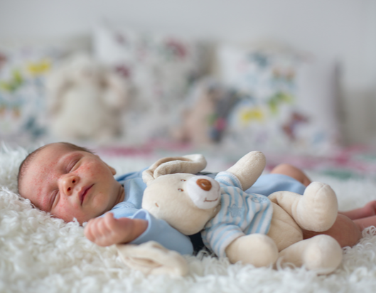 little baby boy lying on a fluffy rug with a skin condition