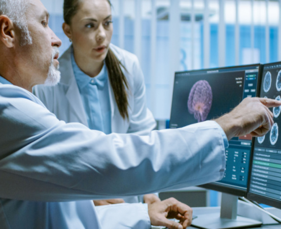 Researchers in a lab reviewing a brain scan