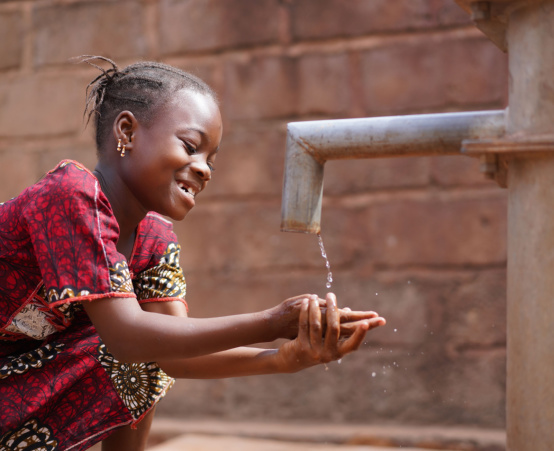 Child getting water from a tap
