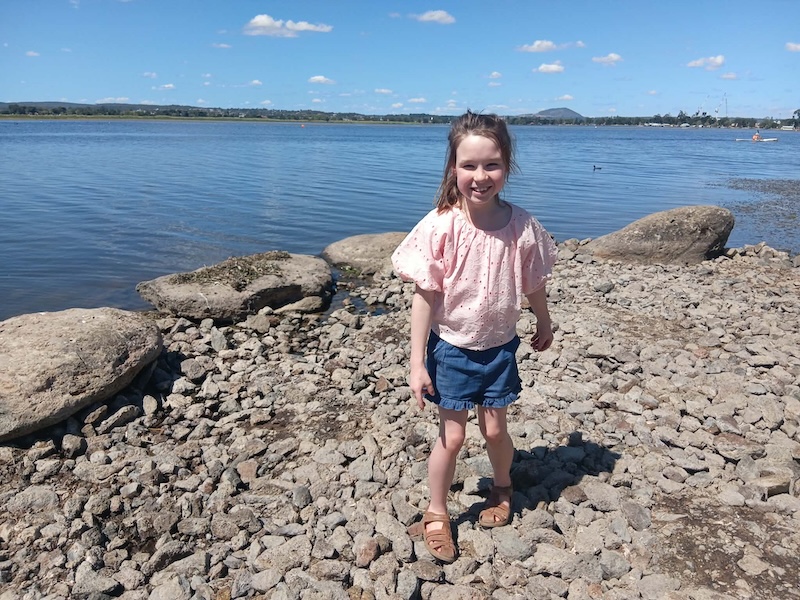 Speech therapy patient Isla smiling on the beach