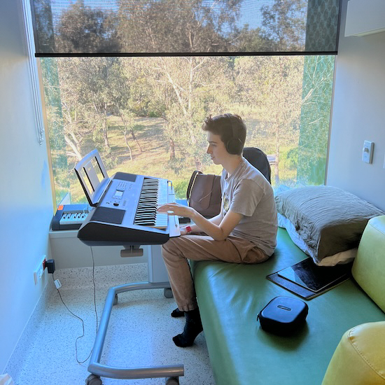 Cancer patient Marco playing his keyboard during a hospital stay