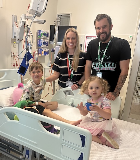 Cancer patient Oliver in hospital with his mum Jacqui, dad Terry and sister Piper