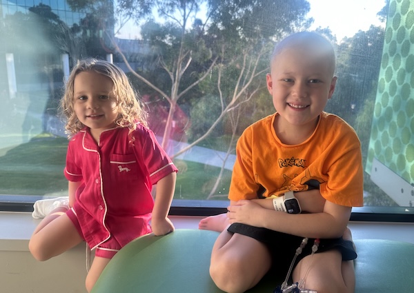 Oliver, wearing the Apple Watch, with his sister Piper at hospital