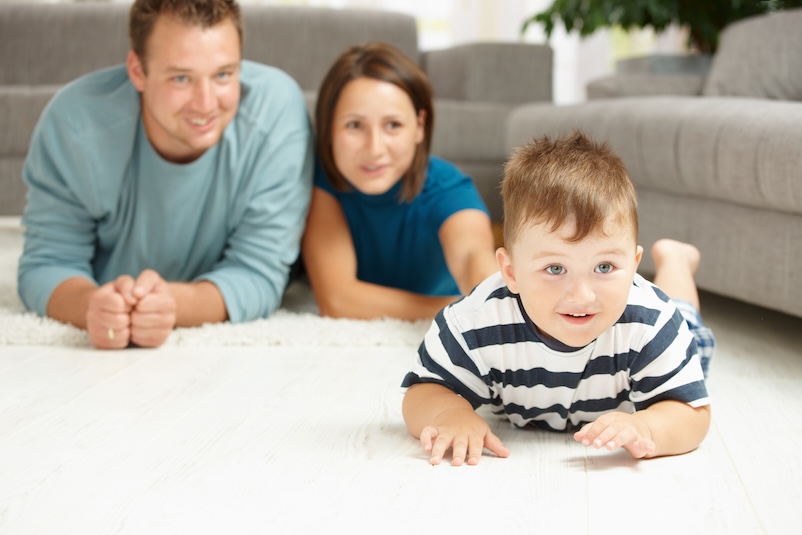 a child crawling in front of his parents