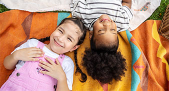 Two children laying on grass