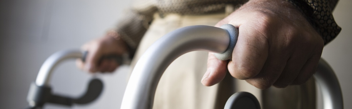 Hands of an elderly person using a walker