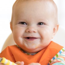 Happy baby holding spoon
