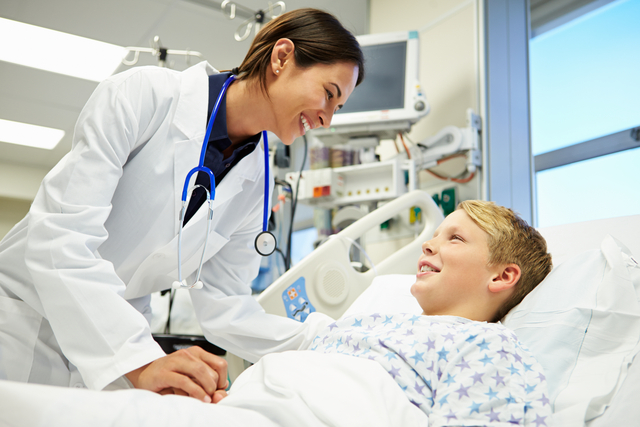 Child in hospital bed with doctor