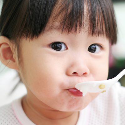 girl being fed with spoon