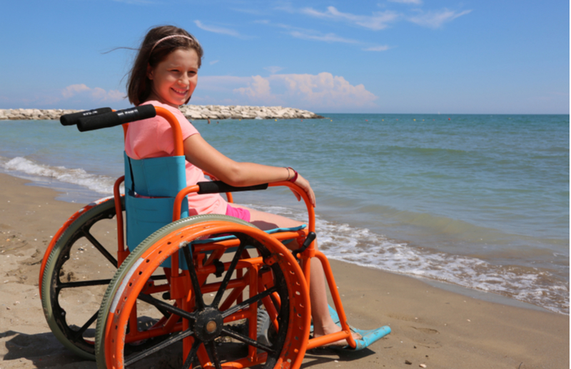 child in wheelchair at beach