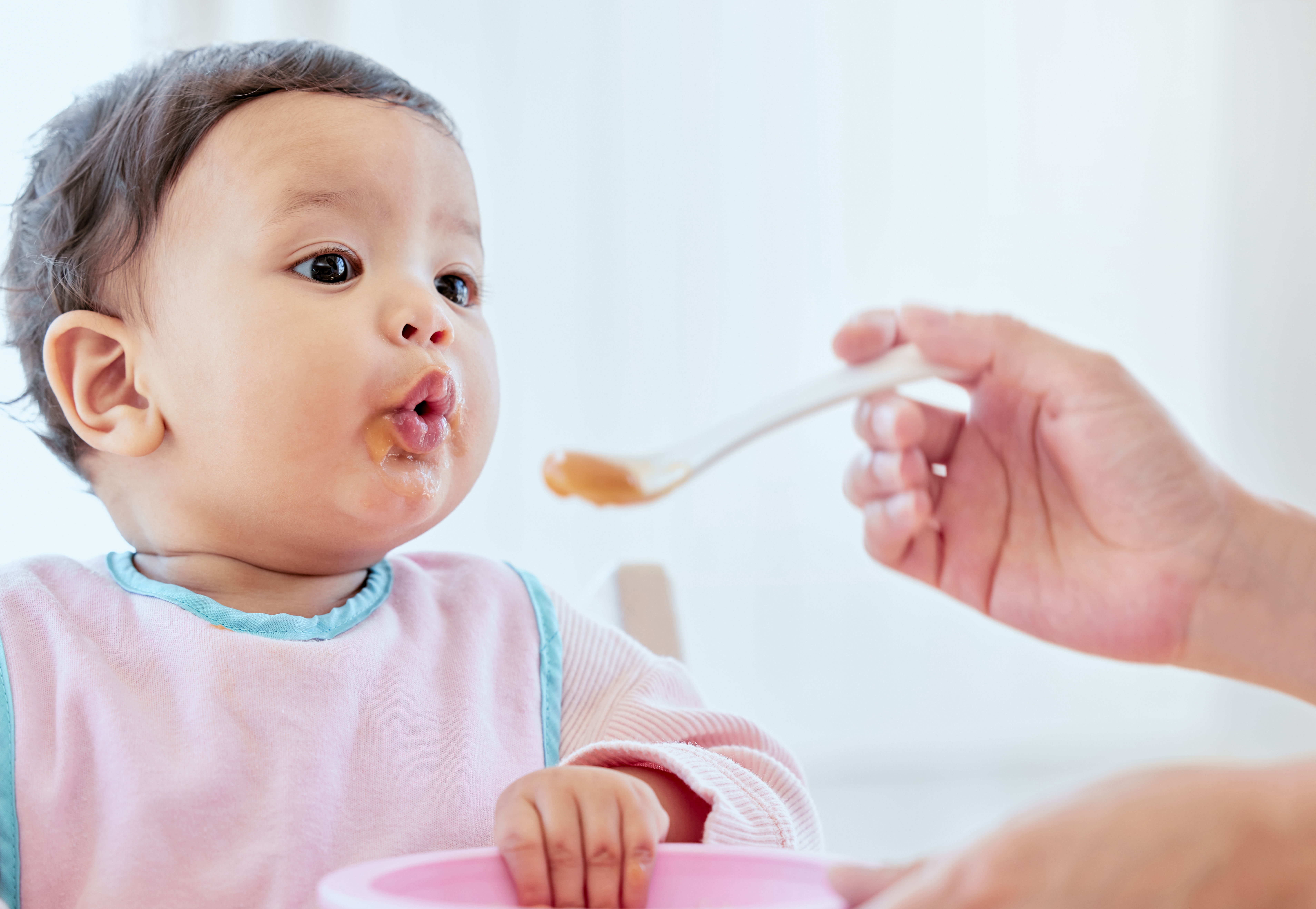 Baby being fed by parent
